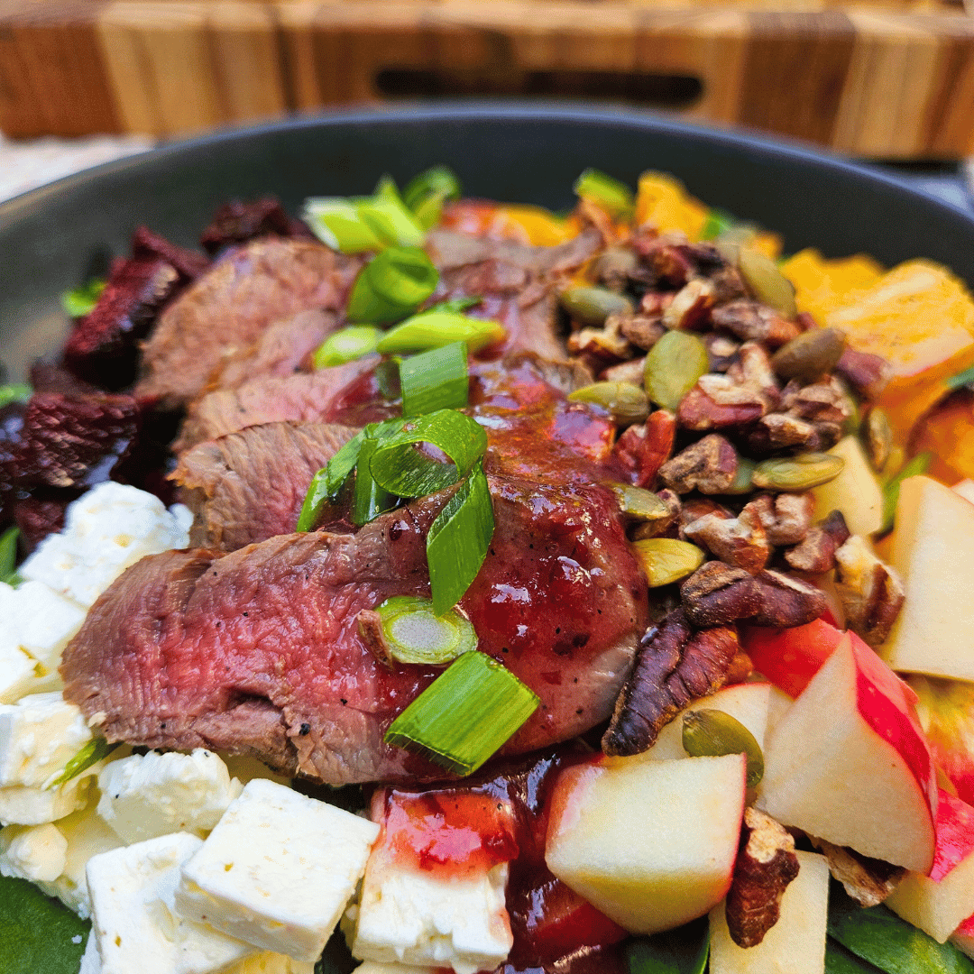 Image of Top with sliced tenderloin and drizzle on the dressing. Top...