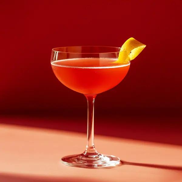 A photo of the Crimson Grapefruit Sour cocktail containing Savage & Cooke Cask Finished Bourbon, Liber & Co. Real Grenadine, Freshly squeezed pink grapefruit juice in a Coupe.