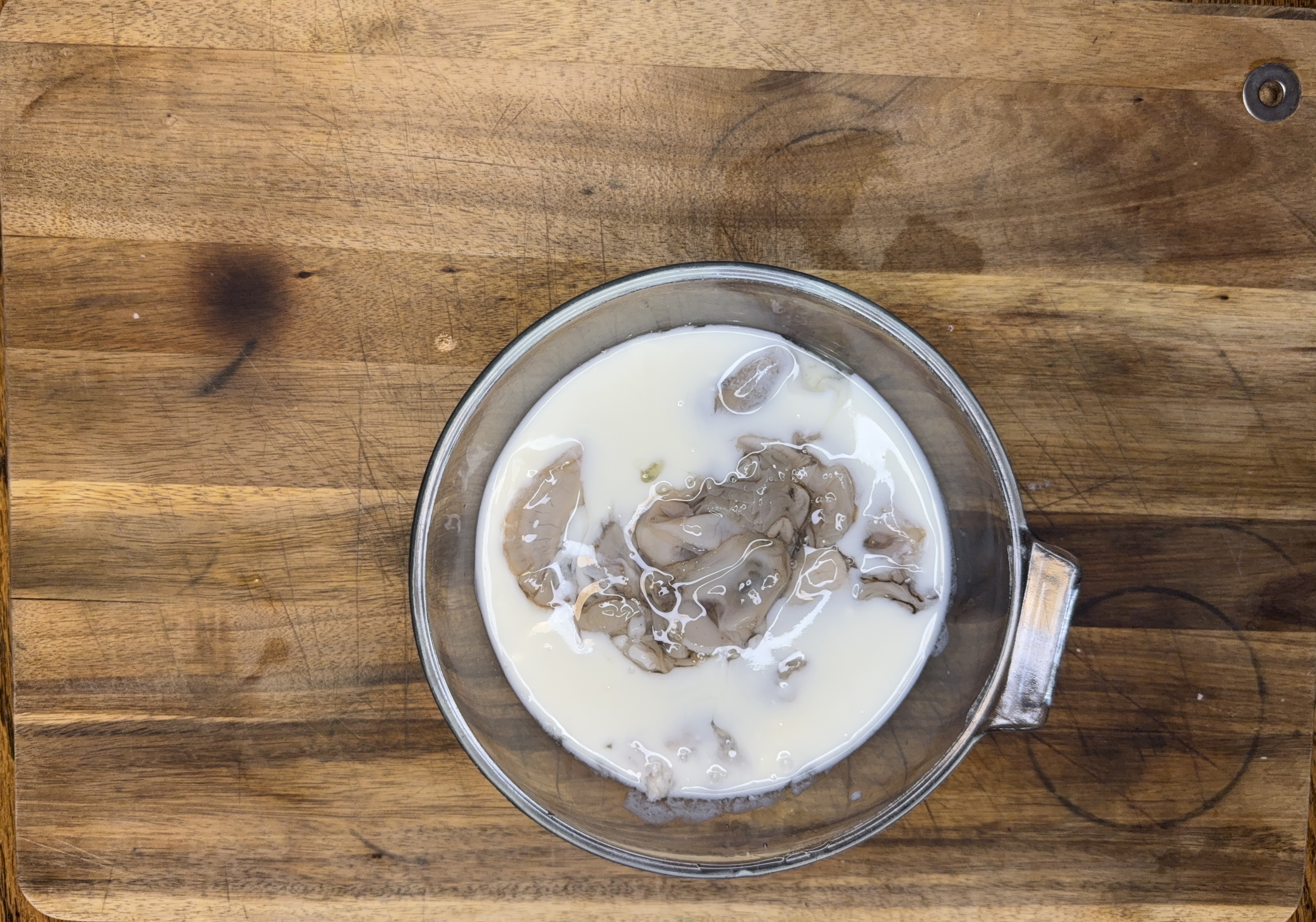 Image of Dredge each oyster in buttermilk, ensuring it's fully coated.