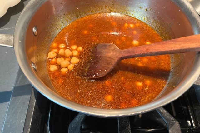 Image of Add chickpeas and simmer until they are warmed. 