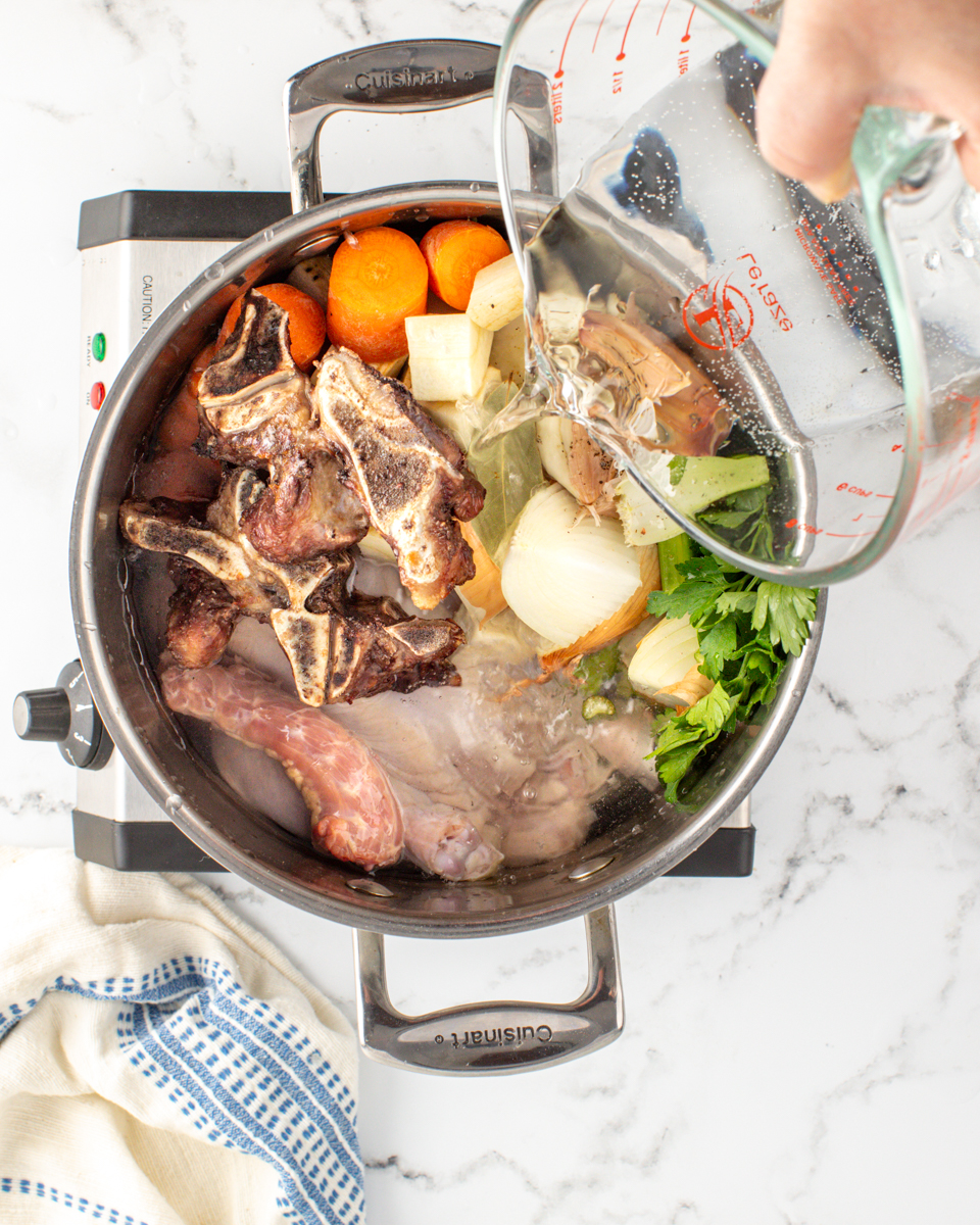 Image of Place chicken, onion, celery, carrots, parsnip, garlic, parsley, bay leaves,...