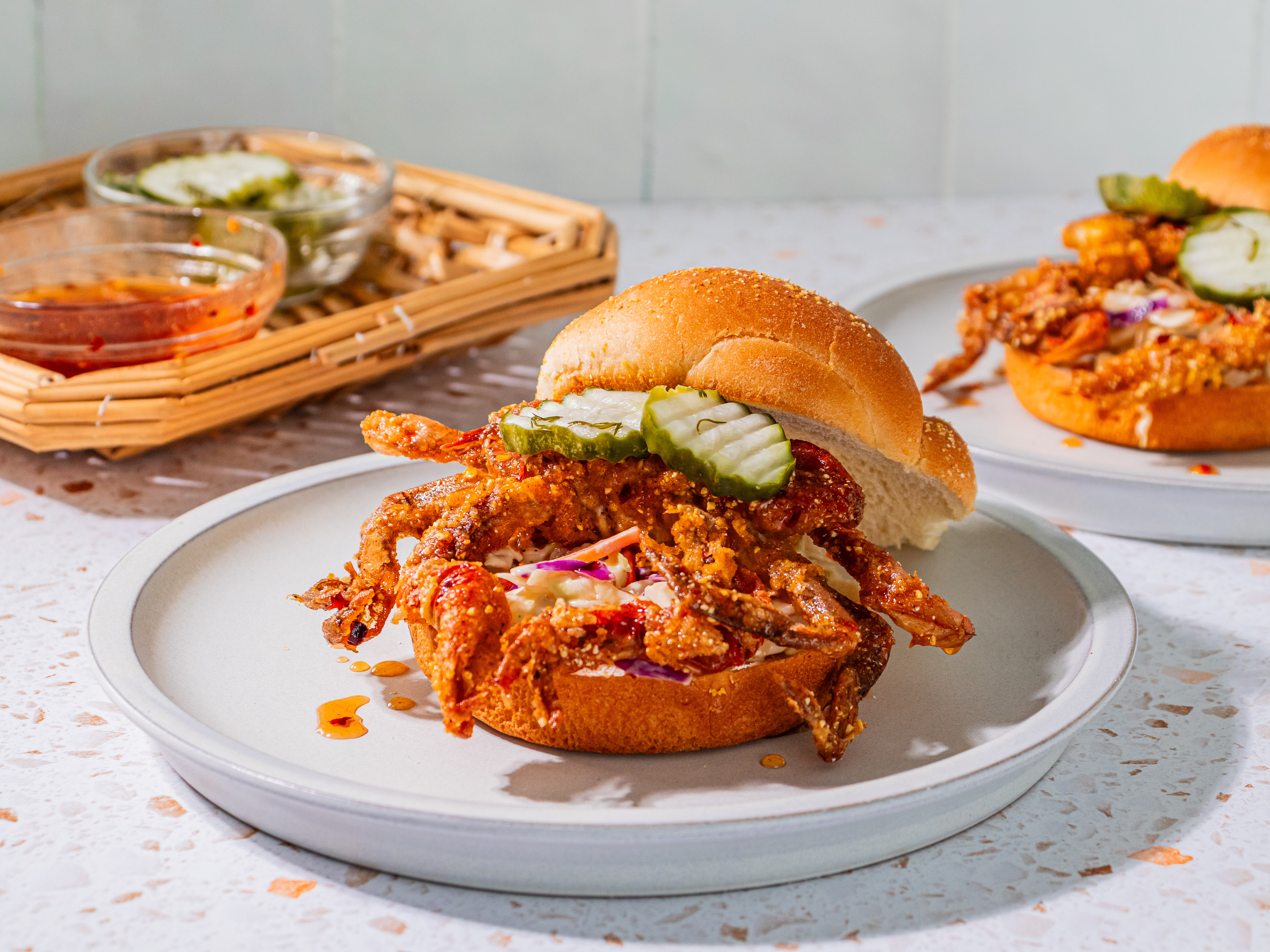 Image of Divide creamy coleslaw between 2 buns. Top with crab. Drizzle...