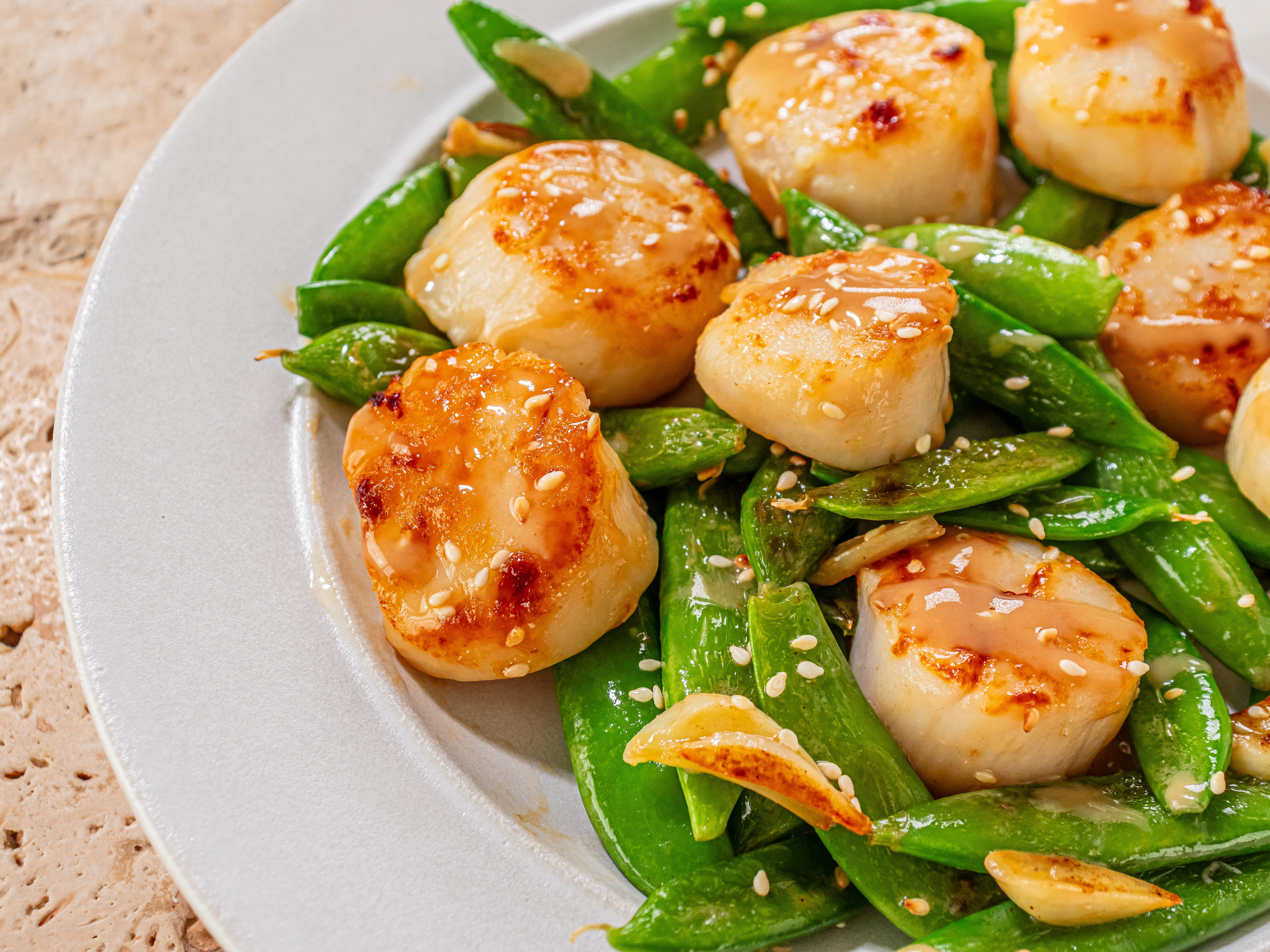 Image of Nestle scallops in between snap peas and drizzle with miso...