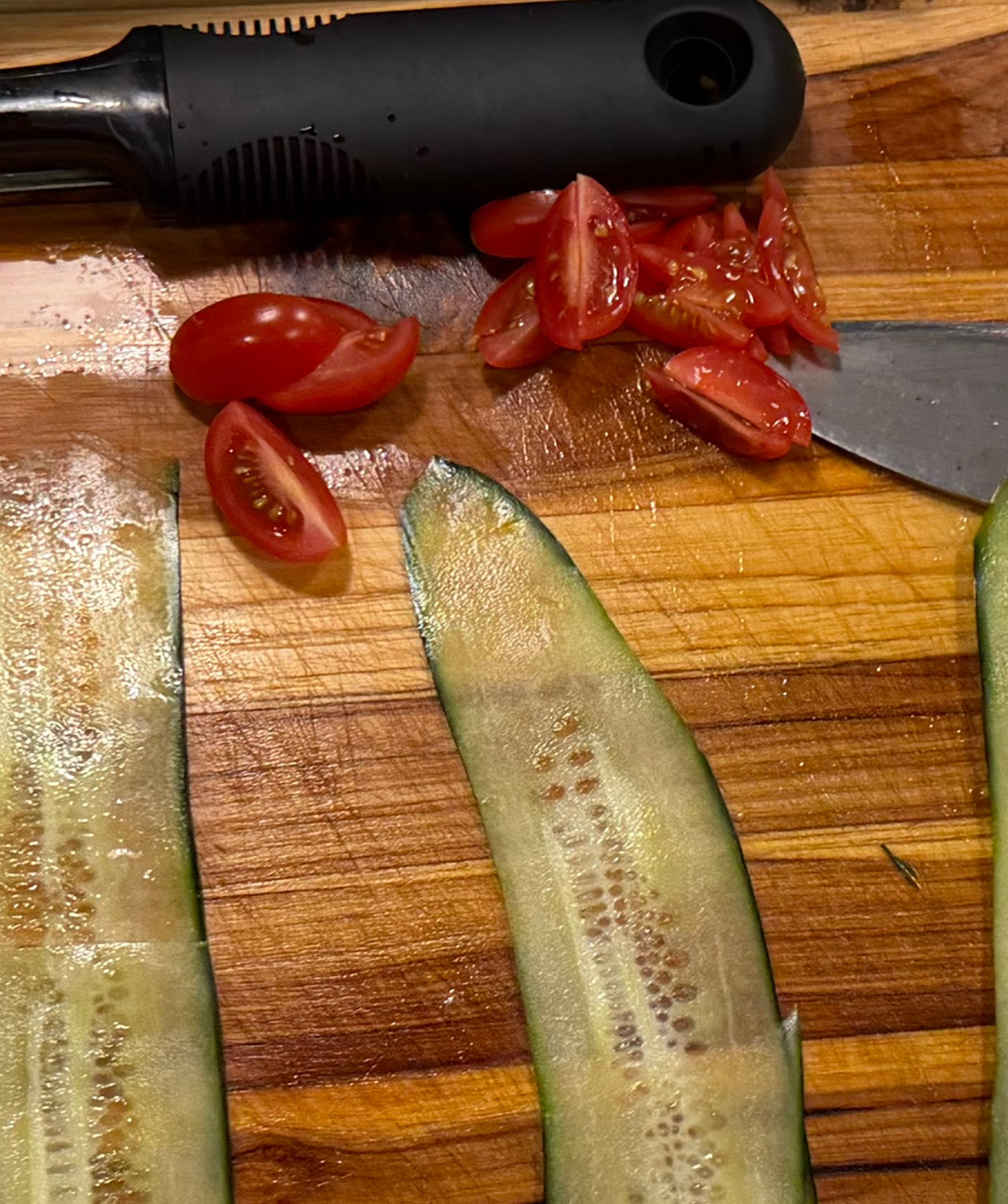 Image of Cut grape tomatoes into quarters or small sections.
