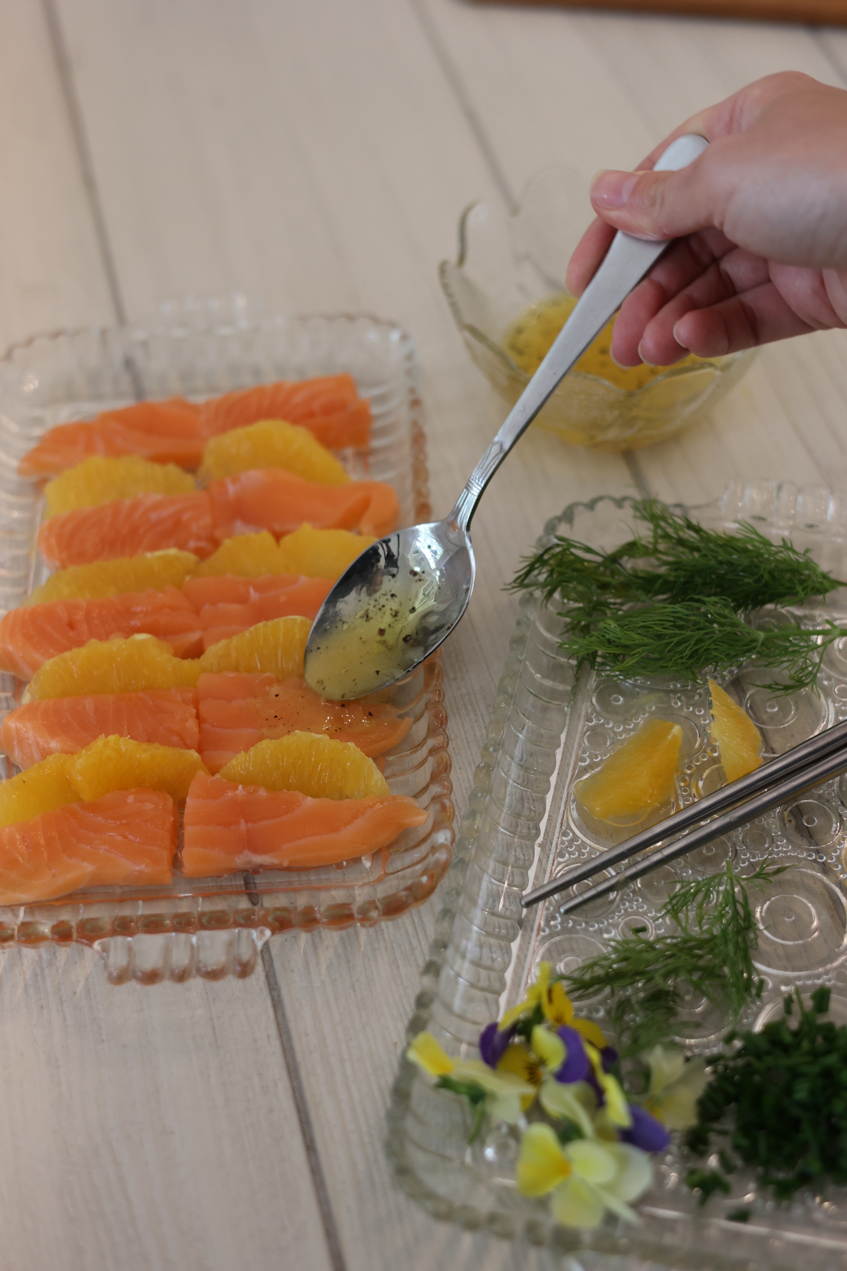 Image of Arrange the fresh orange segments between the salmon slices. Spoon...
