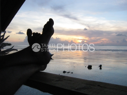 Relaxing, feet on the balcoon, during the sunset on the sea, Tuamotu