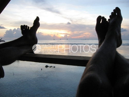 Relaxing, feet on the balcoon, at the sunset on the sea, Tuamotu