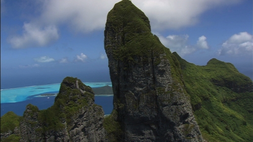 Cinematic aerial shot of the top of the highest mountain of Bora Bora in French Polynesia