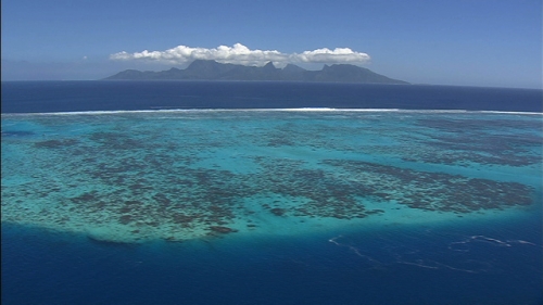 Nice aerial shot of the south Pacific ocean and Moorea, along the reef, from Tahiti, in french Polynesia