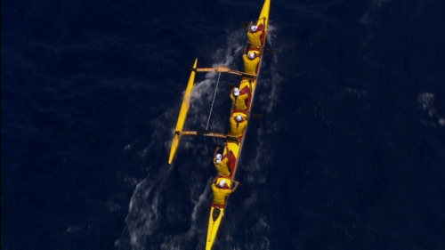 Aerial shot and zoom on a yellow polynesian canoe of Hawaikinui Va