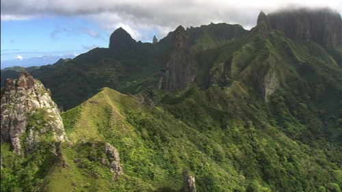 Aerial shot of the top of mountains under the clouds of island ua Pou in Marquesas archipelago, Polynesia