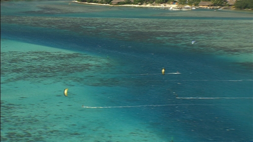 Aerial shot and zoom on kite surfers having fun in the lagoon of Moorea, Society islands in french Polynesia