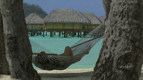 Bora Bora, Couple of people relaxing in a hamac on the beach