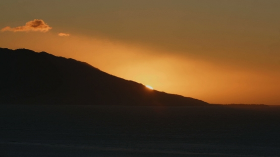 Moorea, very nice and orange sunset behind the island, shot from Tahiti