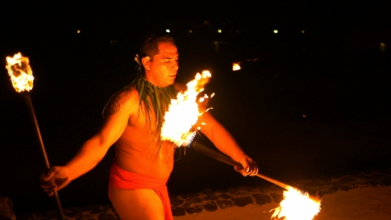 Slowmotion, fire dancer juggling torches at night
