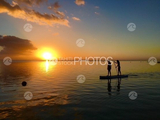 Moorea, Two children paddling through the sunset at Hauru beach 