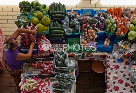 Market of Papeete, lady selling vegetables and fruits on stand