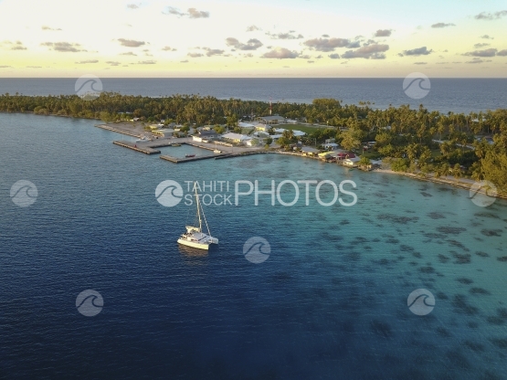 Fakarava aerial by drone, northen village of the atoll and anchored sailing boat