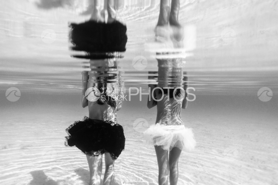 Two women walking in the lagoon, view from underwater