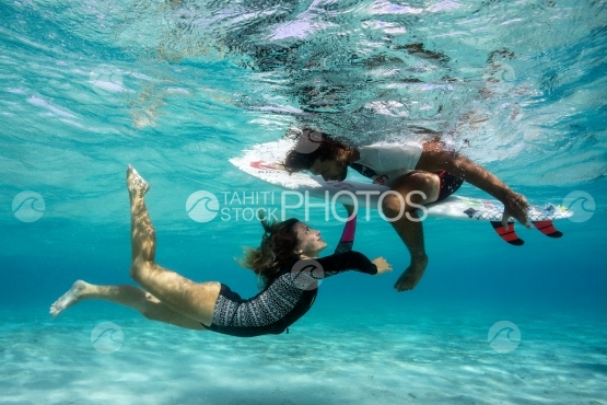 Woman and man on a surf board, shot underwater