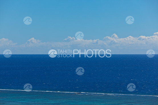 Blue ocean under blue sky and barrier reef
