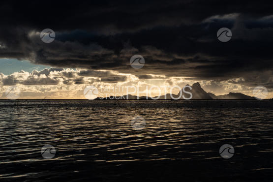 Bora Bora, island under dark clouds before the sunset