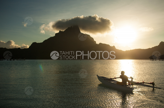 Polynesian on pirogue, paddling on the lagoon of Bora Bora
