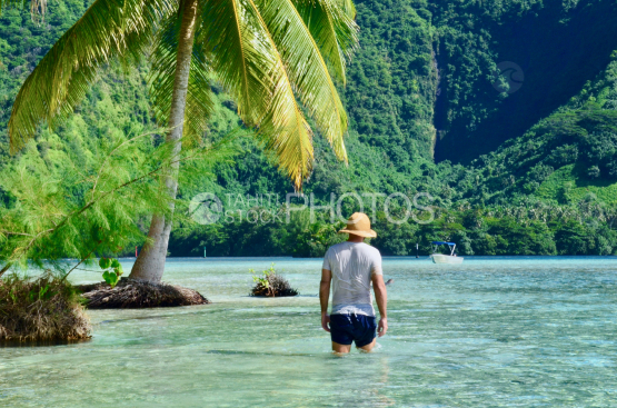 Man with hat walking in lagoon