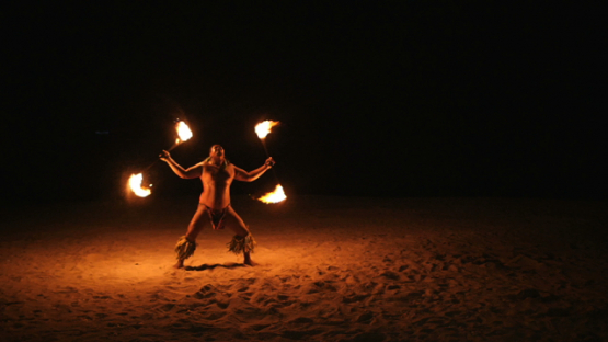 Bora Bora, slow motion shot of fire dancer on white sand by night