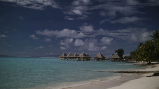 Bora Bora, view on a luxury hotel and bungalow from the white sand beach, slow motion