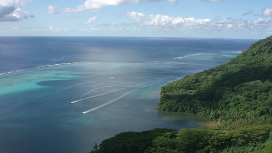 Aerial view of Huahine, Leeward islands, along hills and lagoon, 4K UHD