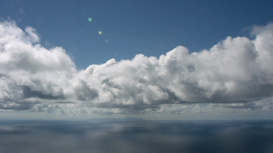 Aerial view of Huahine from ocean, Leeward islands, under the clouds, 4K UHD