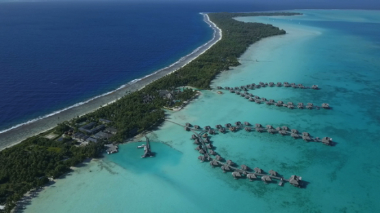 Bora Bora, aerial drone video of a luxury overwater hotel in the lagoon by the reef, leeward islands, polynesia