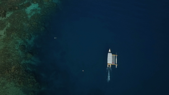 Bora Bora, aerial drone video above an outrigger boat in the lagoon, leeward islands, Polynesia