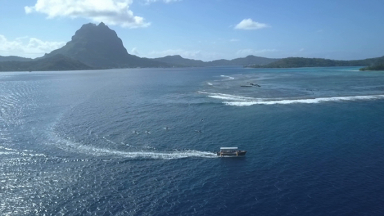 Bora Bora, aerial drone video of outrigger boat in the lagoon, leeward islands, Polynesia
