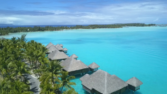 Bora Bora, aerial drone video above a luxury overwater hotel in the lagoon, leeward island, polynesia