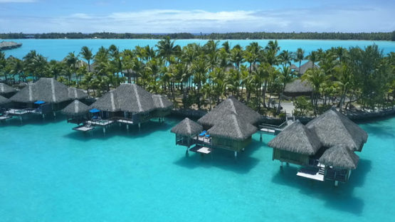 Bora Bora, aerial drone video along a luxury overwater hotel in the lagoon, leeward island, polynesia