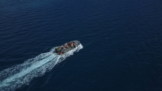 Bora Bora, aerial drone video of a barge with passengers in the lagoon, leeward island, polynesia 4K UHD