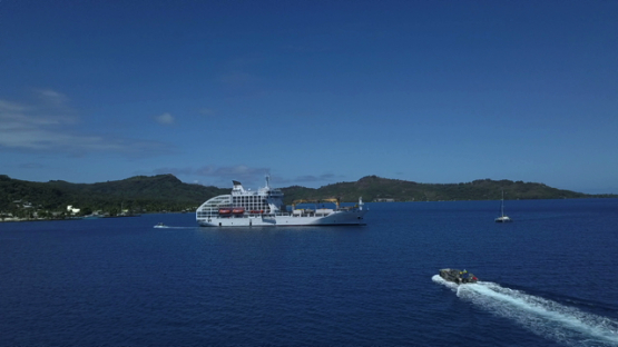 Bora Bora, aerial drone video of cargo cruise ship moored in the lagoon, leeward island, polynesia 4K UHD