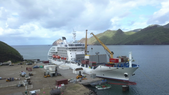 Nuku Hiva, aerial drone video of cargo ship moored in Taiohae harbour, Marquesas islands, Polynesia 4K UHD