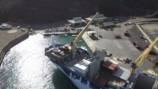Ua Pou, aerial drone video of cargo ship unloading goods on the dock, marquesas islands, polynesia, 4K UHD