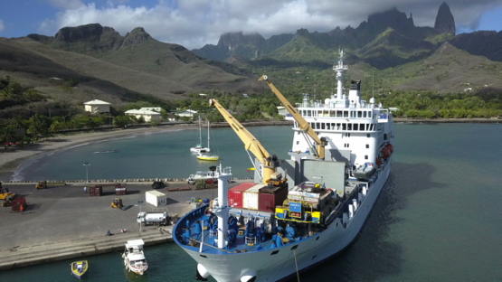 Ua Pou, aerial drone video of cargo ship unloading goods on the dock, marquesas islands, polynesia, 4K UHD