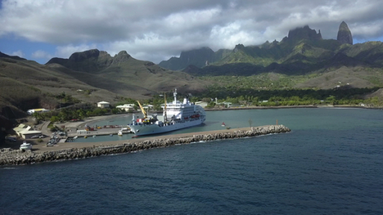 Ua Pou, aerial drone video of cargo ship unloading goods on the dock, marquesas islands, polynesia, 4K, UHD