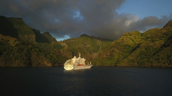 Fatu Hiva sunset, aerial drone video of cruise ship anchored in the bay, Hanavave, Marquesas islands, Polynesia, 4K UHD