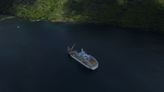 Fatu Hiva, aerial drone video of cruise ship anchored in the Virgins bay, Marquesas islands, Polynesia, 4K UHD