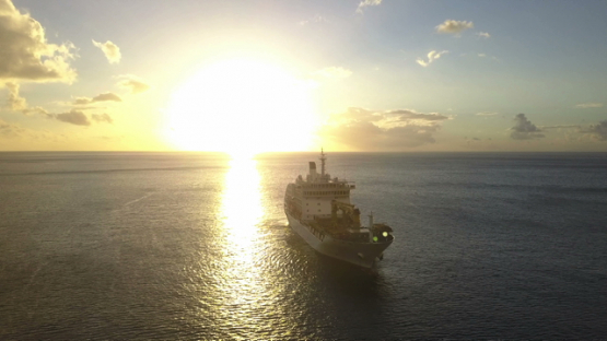 Fatu Hiva, aerial drone video of sunset and cruise ship anchored in the Virgins bay, Marquesas islands, Polynesia, 4K UHD