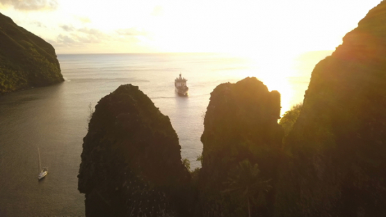 Fatu Hiva sunset, aerial drone video of cruise ship anchored in Hanavave bay, Marquesas islands, Polynesia, 4K UHD
