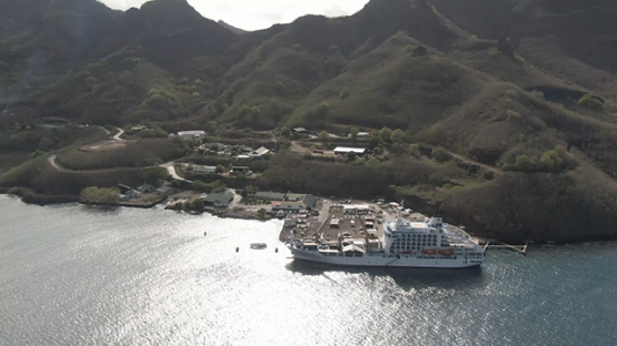 Nuku Hiva, cruise cargo ship discharging containers, Marquesas islands, aerial view by drone 2K7