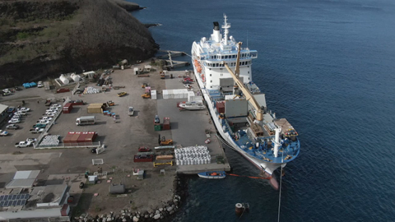 Nuku Hiva, cruise cargo ship discharging containers, Taiohae, Marquesas islands, Polynesia, aerial view by drone 2K7
