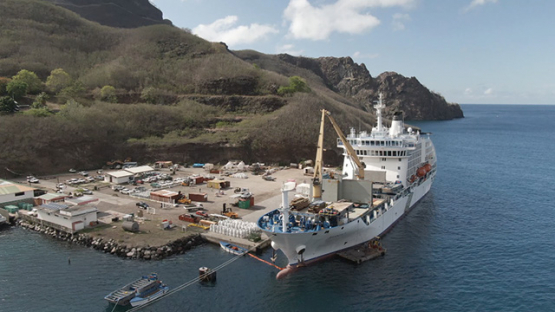 Nuku Hiva, cruise cargo ship discharging containers, Taiohae, Marquesas islands, Polynesia, aerial view by drone 2K7